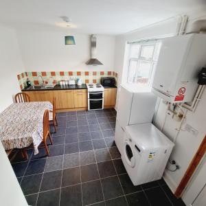 uma pequena cozinha com uma mesa e um frigorífico em Sheridan House I Long or Short Stay I Special Rate Available em Derby
