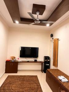 a living room with a flat screen tv and a ceiling at Izi Airport Stay in Chennai