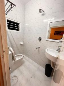 a white bathroom with a sink and a toilet at Izi Airport Stay in Chennai