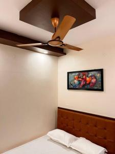 a bedroom with a ceiling fan and a painting on the wall at Izi Airport Stay in Chennai