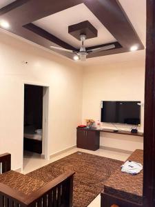 a living room with a ceiling fan and a flat screen tv at Izi Airport Stay in Chennai