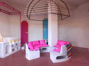 Nefta的住宿－達爾日酒店，带两张双层床和粉红色椅子的客房