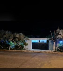 a white garage with palm trees in front of it at Cabaña los Abuelos in Coveñas