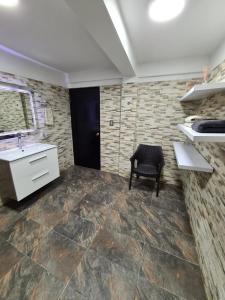 eine Küche mit einem Waschbecken und einem Stuhl in einem Zimmer in der Unterkunft Cabaña los Abuelos in Coveñas