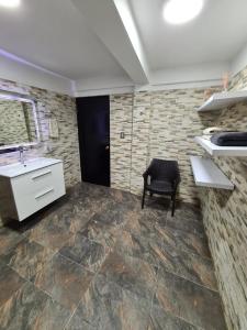 a kitchen with a sink and a chair in a room at Cabaña los Abuelos in Coveñas