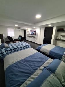 a hotel room with three beds and a tv at Cabaña los Abuelos in Coveñas