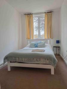 een slaapkamer met een groot bed en een raam bij 3 bedroom flat 10 mins walk to Bay and City center Free Parking in Cardiff