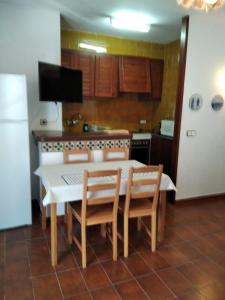 a kitchen with a table and chairs and a kitchen with a refrigerator at Apartamento Siesta Mar 1 Apartamento 26 Cala en Porter in Cala en Porter