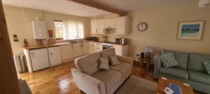 sala de estar con sofá y cocina en Rockley Cottage, close to Eden project and Fowey. en Bodmin