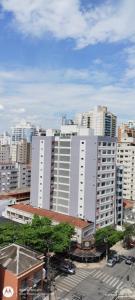 a large white building in front of a city at Loft Do Serginho in Santos