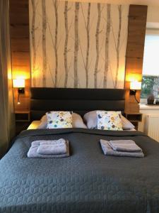 una camera da letto con un letto e due asciugamani di APARTMÁN RIVIÉRA LIPNO 511-16 a Lipno nad Vltavou