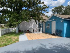 a blue house with a patio and a tree at The Quiet Sunshine Studio in Jacksonville