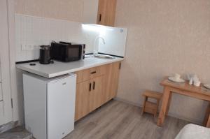 a small kitchen with a sink and a microwave at Студия №1 LifeHouseAlmaty в ЖК Теремки-2 in Almaty