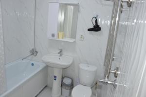a white bathroom with a toilet and a sink at Студия №1 LifeHouseAlmaty в ЖК Теремки-2 in Almaty