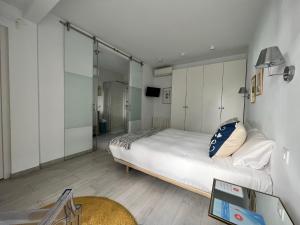 a bedroom with a large bed with white cabinets at Chipibeach, Hostal Boutique in Chipiona