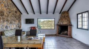 ein Wohnzimmer mit einem Tisch und einem Kamin in der Unterkunft CASA RURAL LA CHOZA DE MINDO in Granada