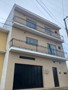 aominium building with a balcony with black doors at Apartamentos C7 in Cunha