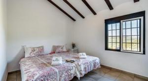 a bedroom with a bed and a window at CASA RURAL LA CHOZA DE MINDO in Granada