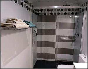 baño con ducha y algunas toallas en un estante en PRIMERA LINEA DE PLAYA, en Mojácar