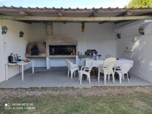 un patio con mesa, sillas y horno de pizza en Amplia casa en piriapolis a 4 cuadras de playa san francisco, en Piriápolis