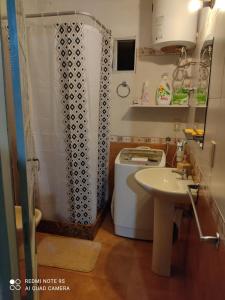 y baño con ducha, lavabo y lavadora. en Amplia casa en piriapolis a 4 cuadras de playa san francisco, en Piriápolis