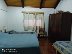 1 dormitorio con 1 cama, vestidor y ventana en Amplia casa en piriapolis a 4 cuadras de playa san francisco, en Piriápolis