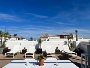 a group of chairs and tables on a roof at Chipibeach, Hostal Boutique in Chipiona