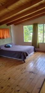 1 dormitorio con cama y ventana grande en Casa cerca del lago en Lago Puelo