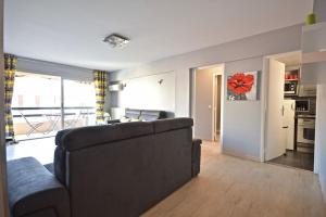 salon z kanapą i kuchnią w obiekcie Appartement cœur de juan les pins w mieście Antibes