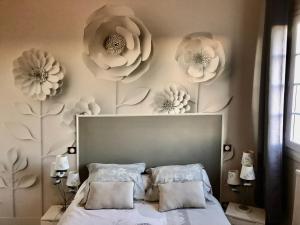 1 dormitorio con 1 cama con flores en la pared en Logis de Mélisandre, en Vaux-sur-Mer