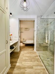 a bathroom with a walk in shower and a sink and a mirror at Chipibeach, Hostal Boutique in Chipiona