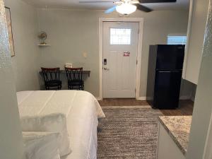 a bedroom with a bed and a table and a refrigerator at The Quiet Sunshine Studio in Jacksonville