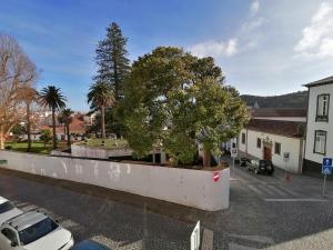 una pared blanca con un árbol en un estacionamiento en Miragaia Star Apartments en Angra do Heroísmo