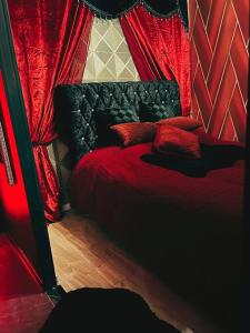 - une chambre avec un lit rouge et des rideaux rouges dans l'établissement Suite Jeux d’Amour Jacuzzi / Love Room, à Saint-Dié-des-Vosges