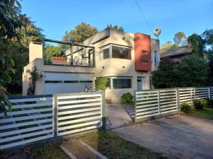 una cerca blanca frente a una casa en Sofia del Bosque en Mar del Plata