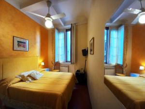 a hotel room with two beds and two windows at Hotel Tourist House in Florence