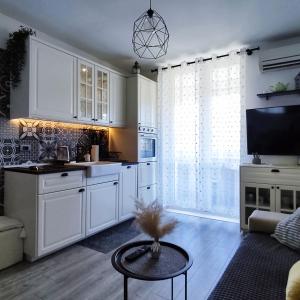 a kitchen with white cabinets and a table in a room at Sweet home R&M in Split