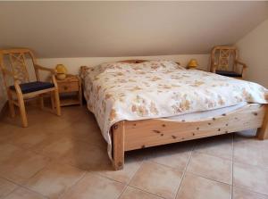 a bedroom with a wooden bed and two chairs at Wanderoase Ibental in Asbach