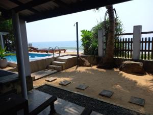 a patio with a pool and the ocean in the background at Asiri Yoga Retreat in Galle