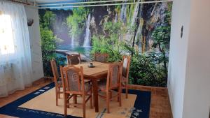 a dining room with a waterfall mural on the wall at Apartman Radovic in Pale