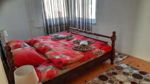 a bedroom with a bed with a red comforter at Apartman Radovic in Pale