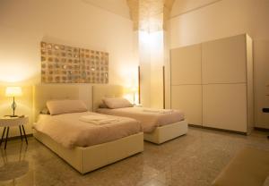 1 Schlafzimmer mit 2 Betten und einem Tisch in der Unterkunft B&B Regina Margherita in Brindisi