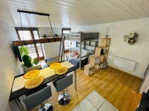 a room with a dining table and a bunk bed at Au Doubs Village in Métabief