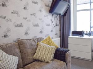 a living room with a couch and a tv at Fionas Cottage in Crieff