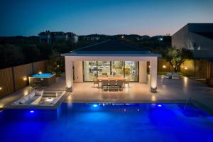 a backyard with a table and a pool at night at Villa Fabiana in Kipseli