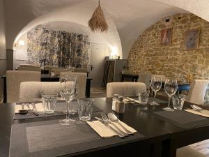 a dining room with a table with wine glasses at Hôtel Restaurant Le Clos Charmant in Vallon-Pont-dʼArc