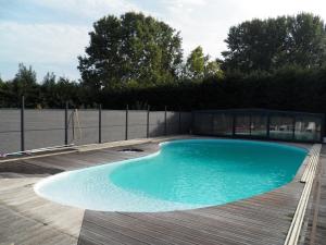 una gran piscina en una terraza de madera en 1 chambre - lit double - Avec salle de bain, en Mervans