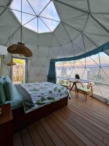 um quarto com uma tenda com uma cama e uma mesa em Ubuntu Glamping em Guanacaste