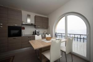 cocina con mesa y sillas y ventana grande en Entire apartments with stunning view, en Cademario