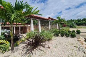 un jardín frente a una casa con palmeras en Ubuntu Glamping, en Guanacaste